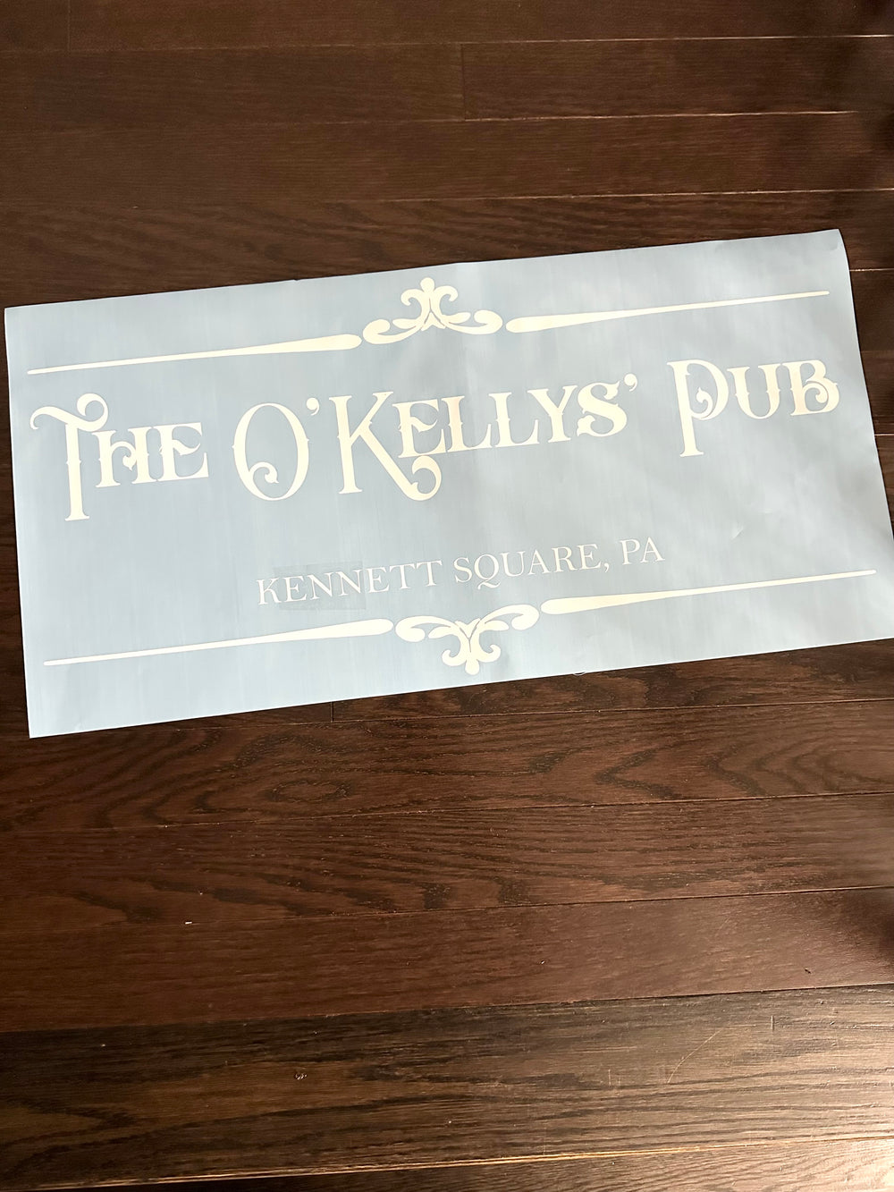 Close-up of The O’Kellys’ Pub lettering on blue backing