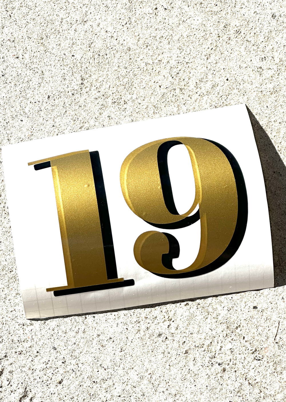 Gold and black 191 number decal on curved backing