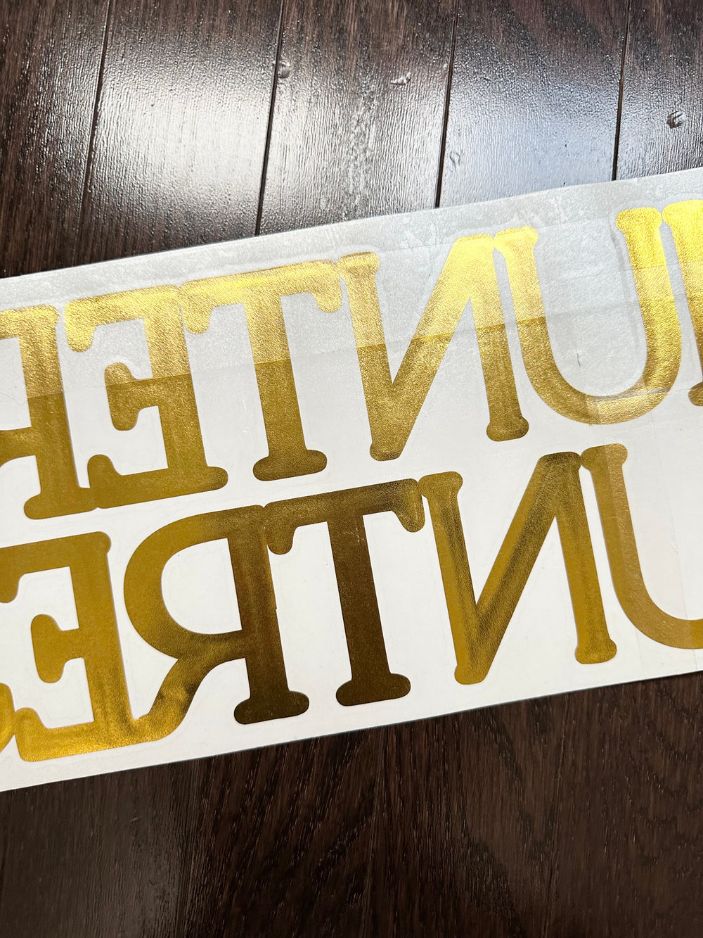 Reverse-oriented gold lettering on backing