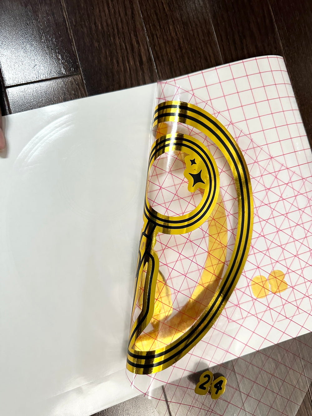 Gold and black circular logo with backing partly peeled
