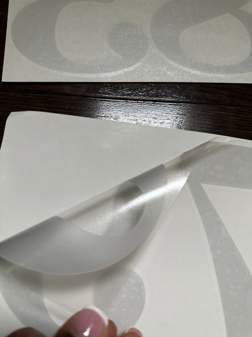 Close-up of frosted lettering being peeled from backing