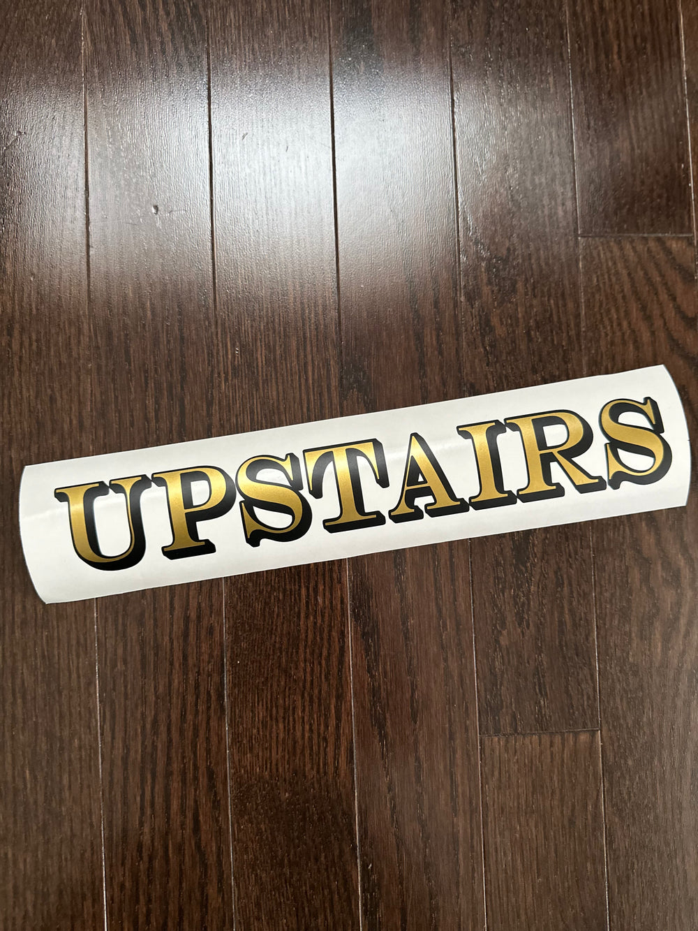 Gold and black Upstairs lettering on backing