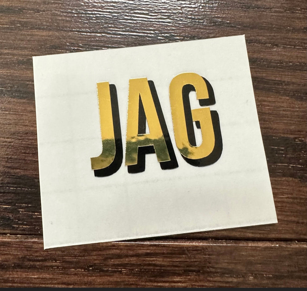 Gold and black JAG lettering on backing