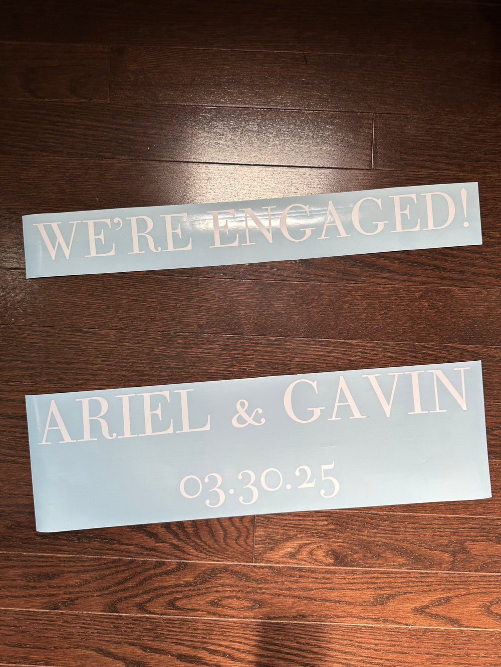 White We’re Engaged and Ariel & Gavin lettering on backing