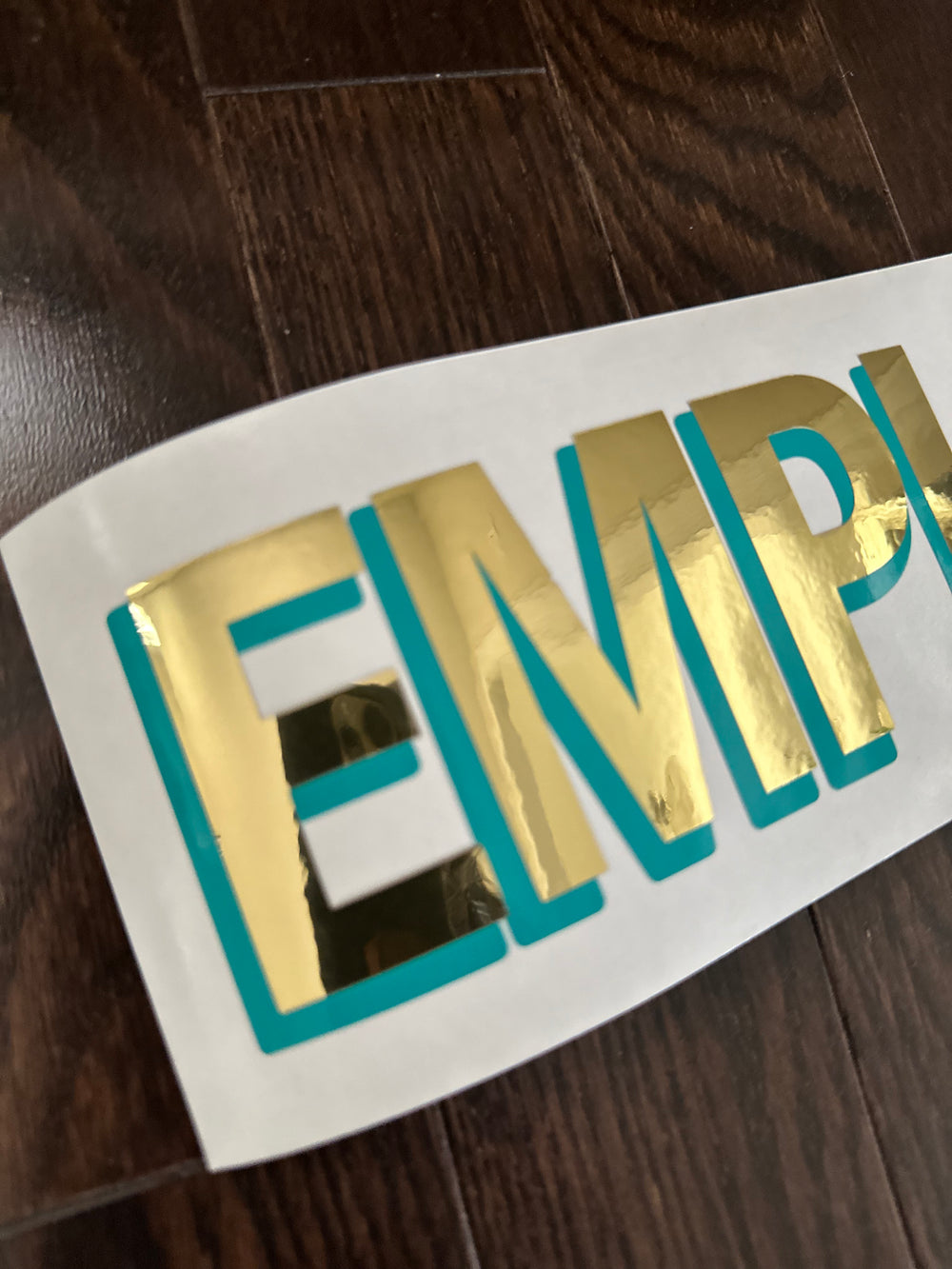 Close-up of gold and teal layered Employees lettering