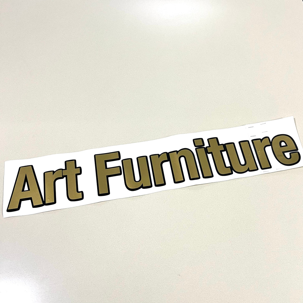 Gold and black Art Furniture lettering