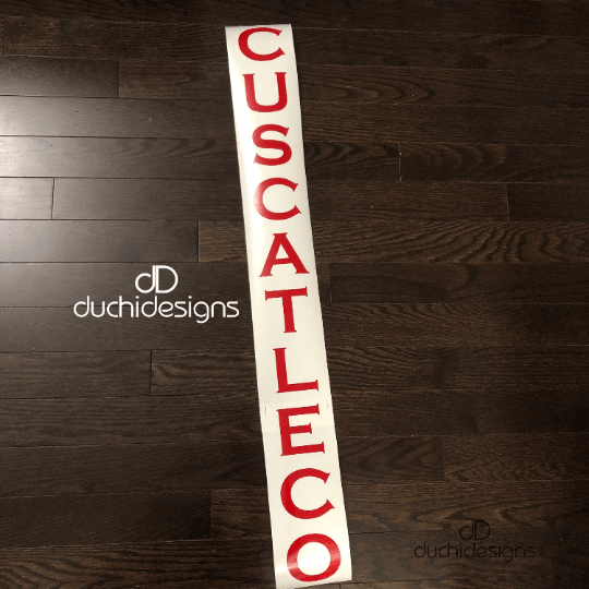 Red CUSCATLECO lettering stacked vertically on backing