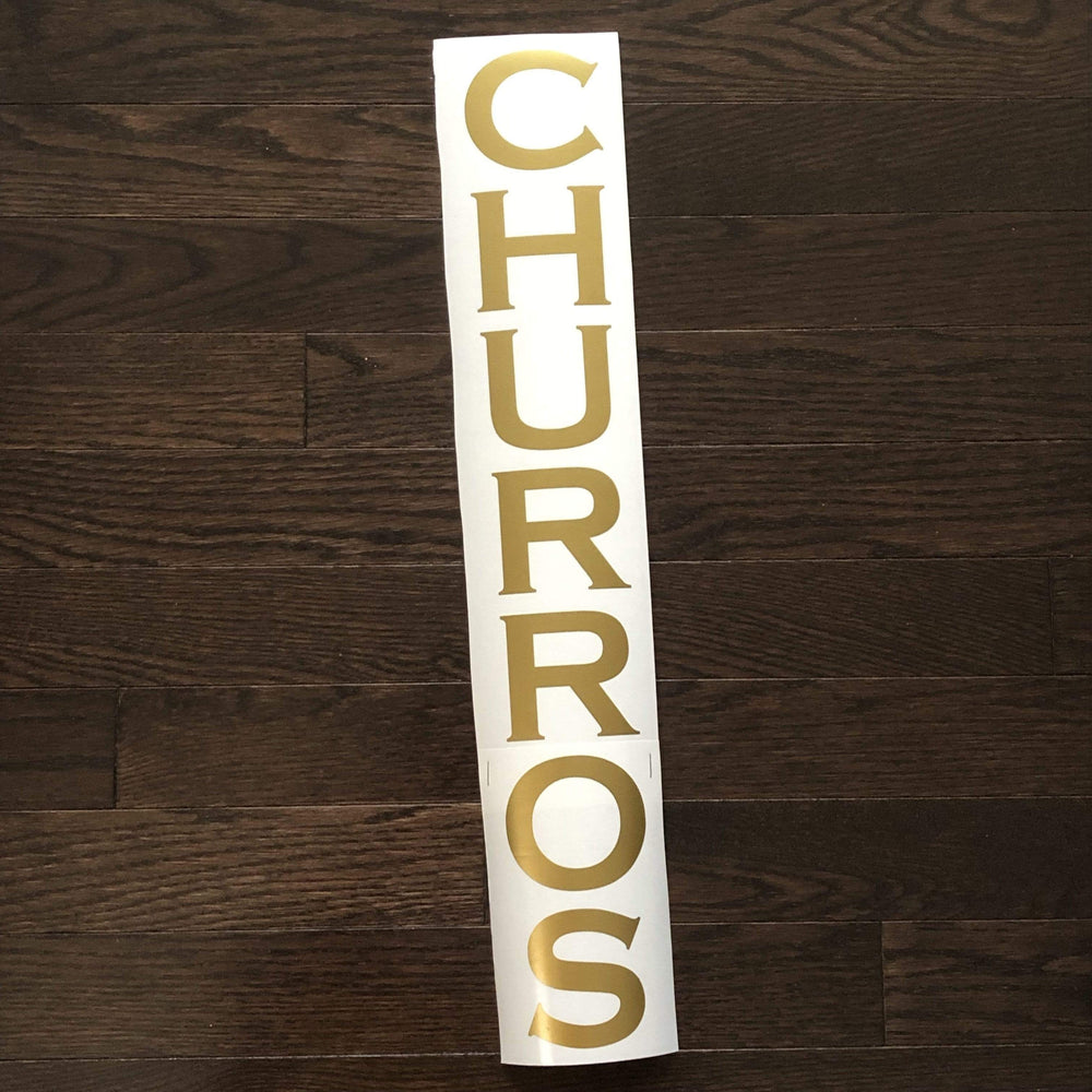 Gold-coloured CHURROS lettering stacked on backing