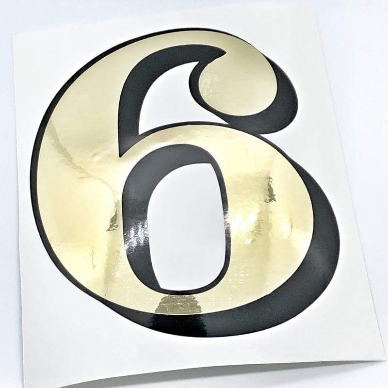 Reflective gold and black single digit 6 on a backing sheet