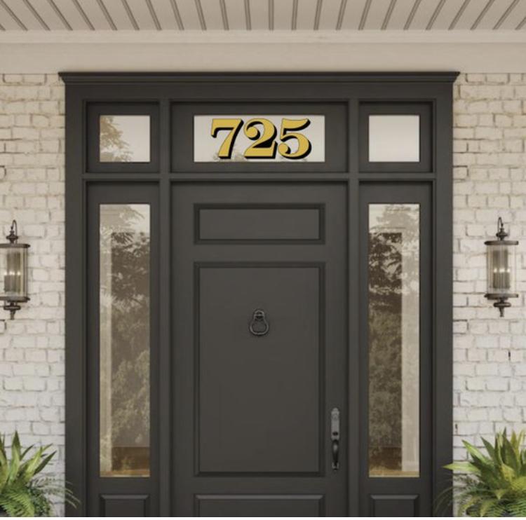 Gold and black 725 numbers above a dark entrance door