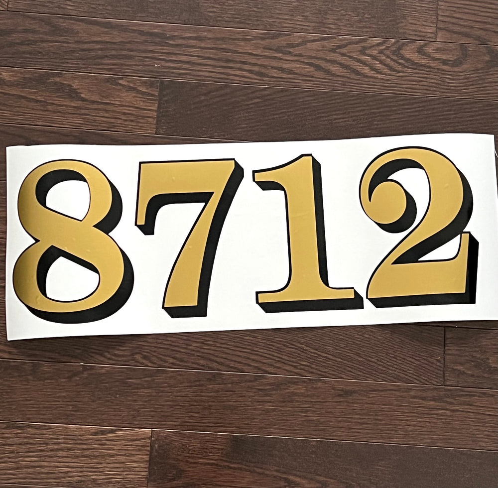 Gold and black 8712 house number decal on backing