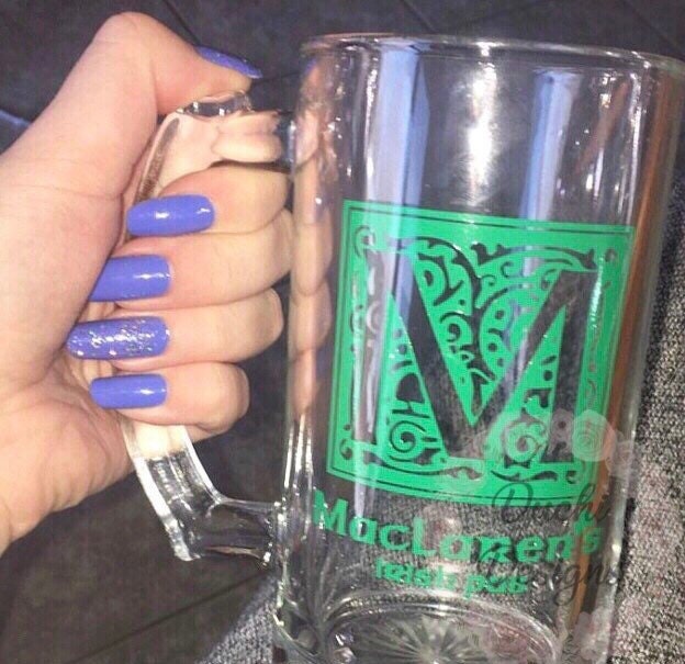 Green decorative initial M applied to a clear mug