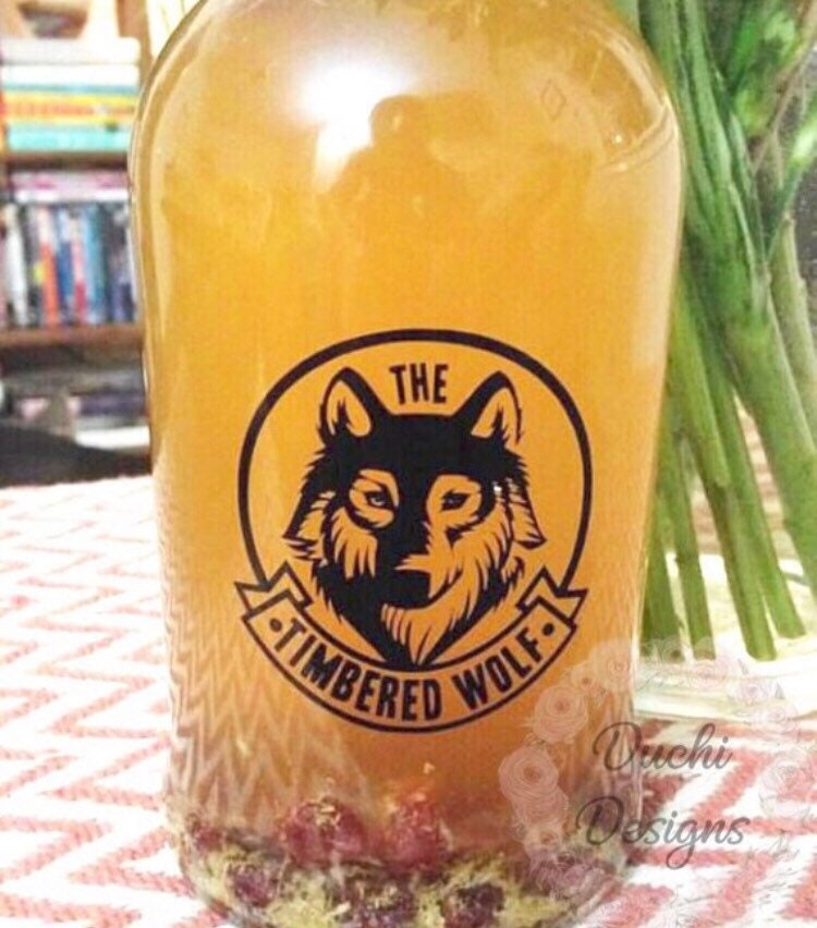 Black Timbered Wolf logo on an orange bottle
