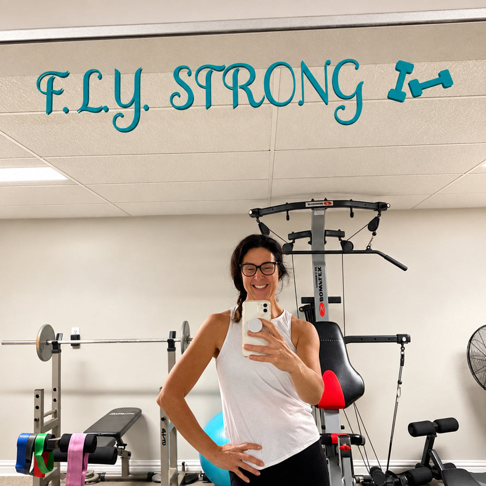 Teal F.L.Y. Strong lettering on a gym mirror