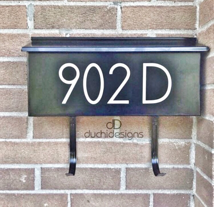 White 902D address lettering on a black mailbox