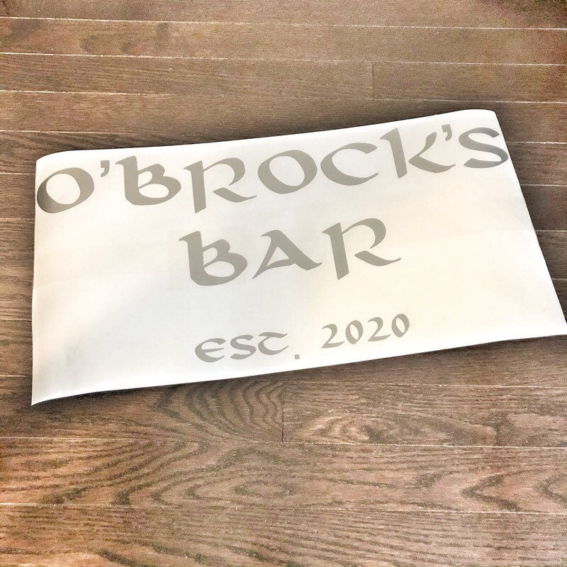 Grey O’Brock’s Bar lettering and establishment date on backing