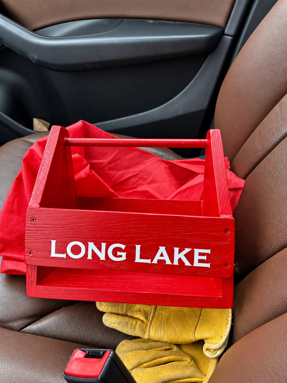 White LONG LAKE lettering on a red tote in a car