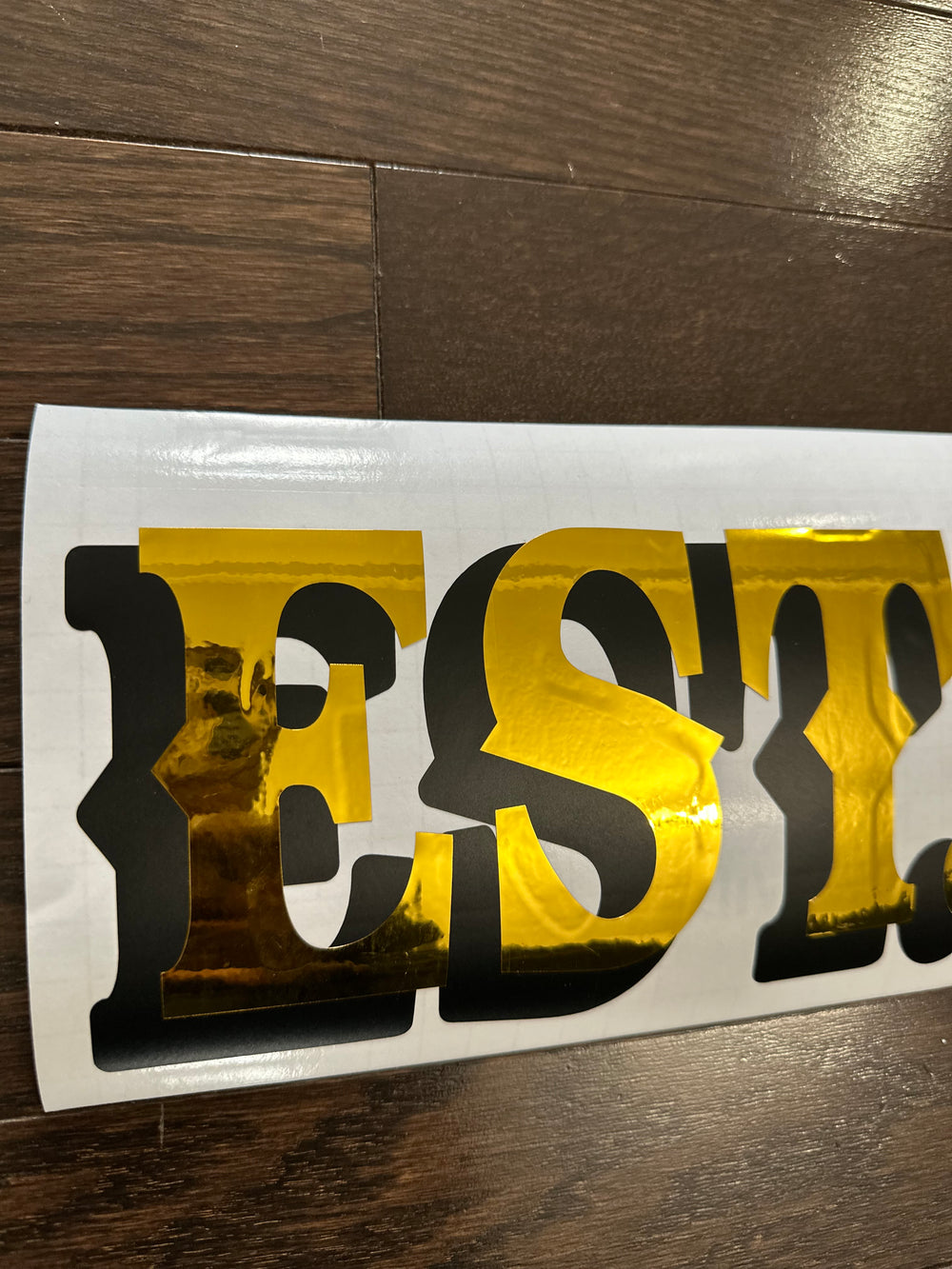 Reflective gold and black Est. lettering close-up
