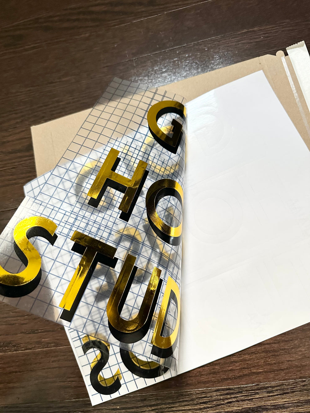 Backing partly peeled from Gold House Studios layered lettering