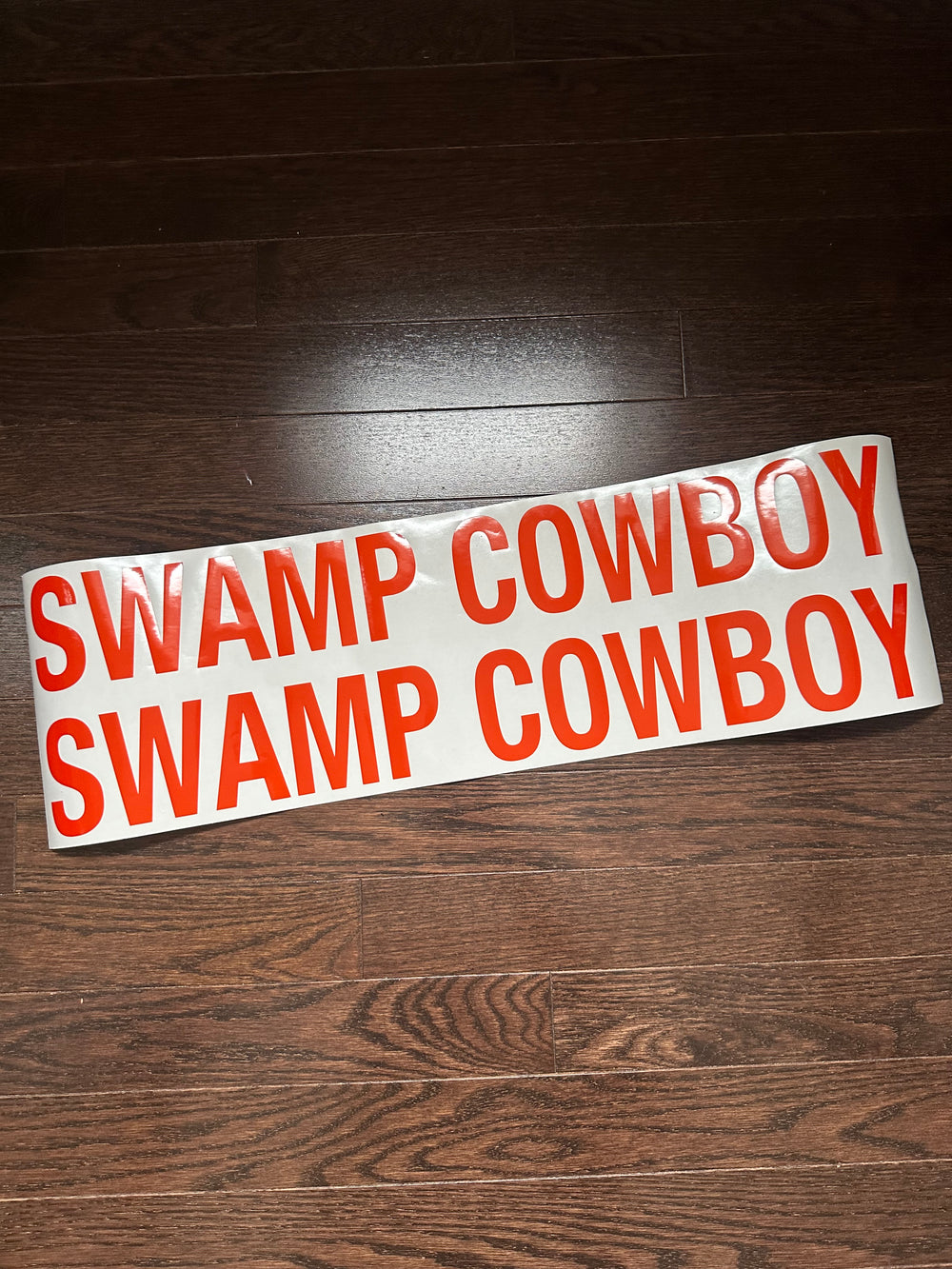 Two red Swamp Cowboy boat-name decals