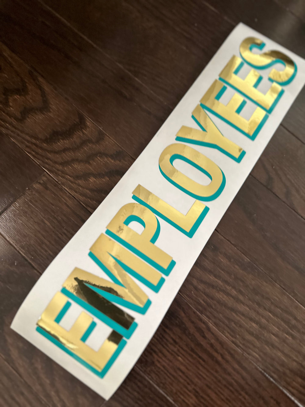 Gold and teal Employees lettering laid diagonally