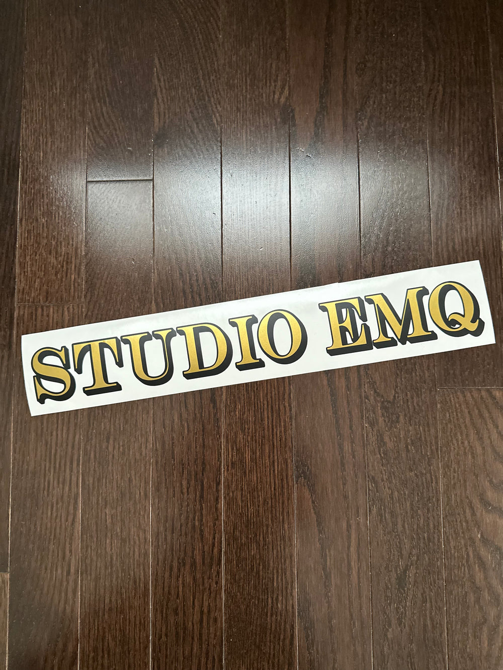 Gold and black Studio EMQ lettering on backing