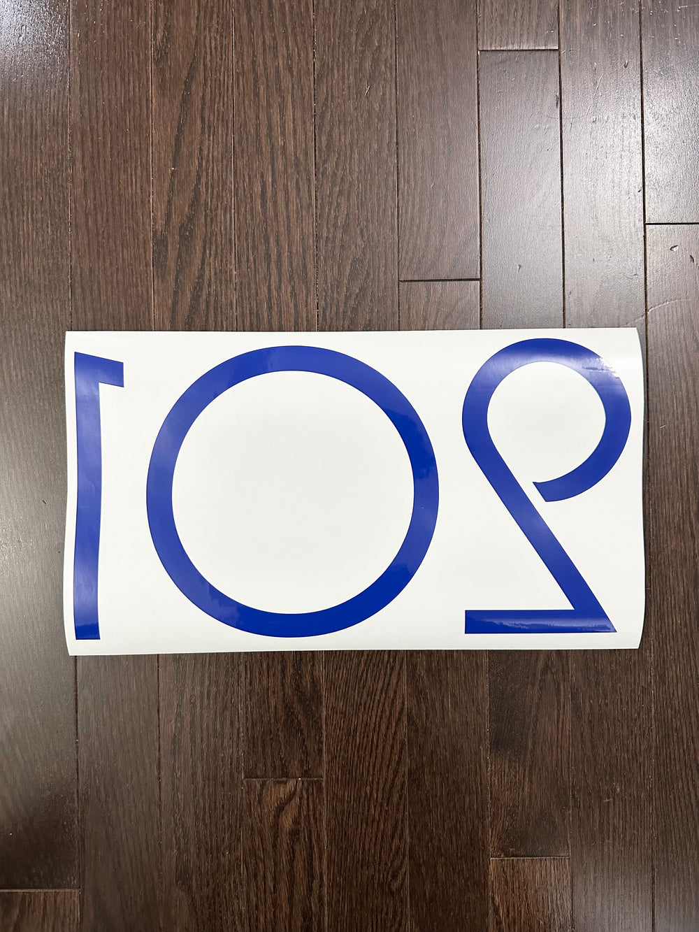 Reverse-oriented blue 201 number decal on backing