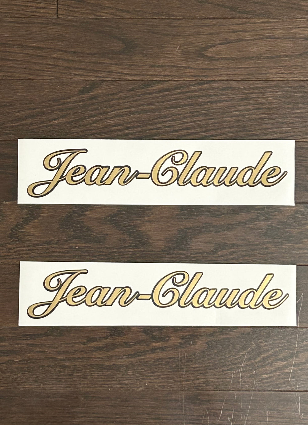 Two gold and black Jean-Claude script decals