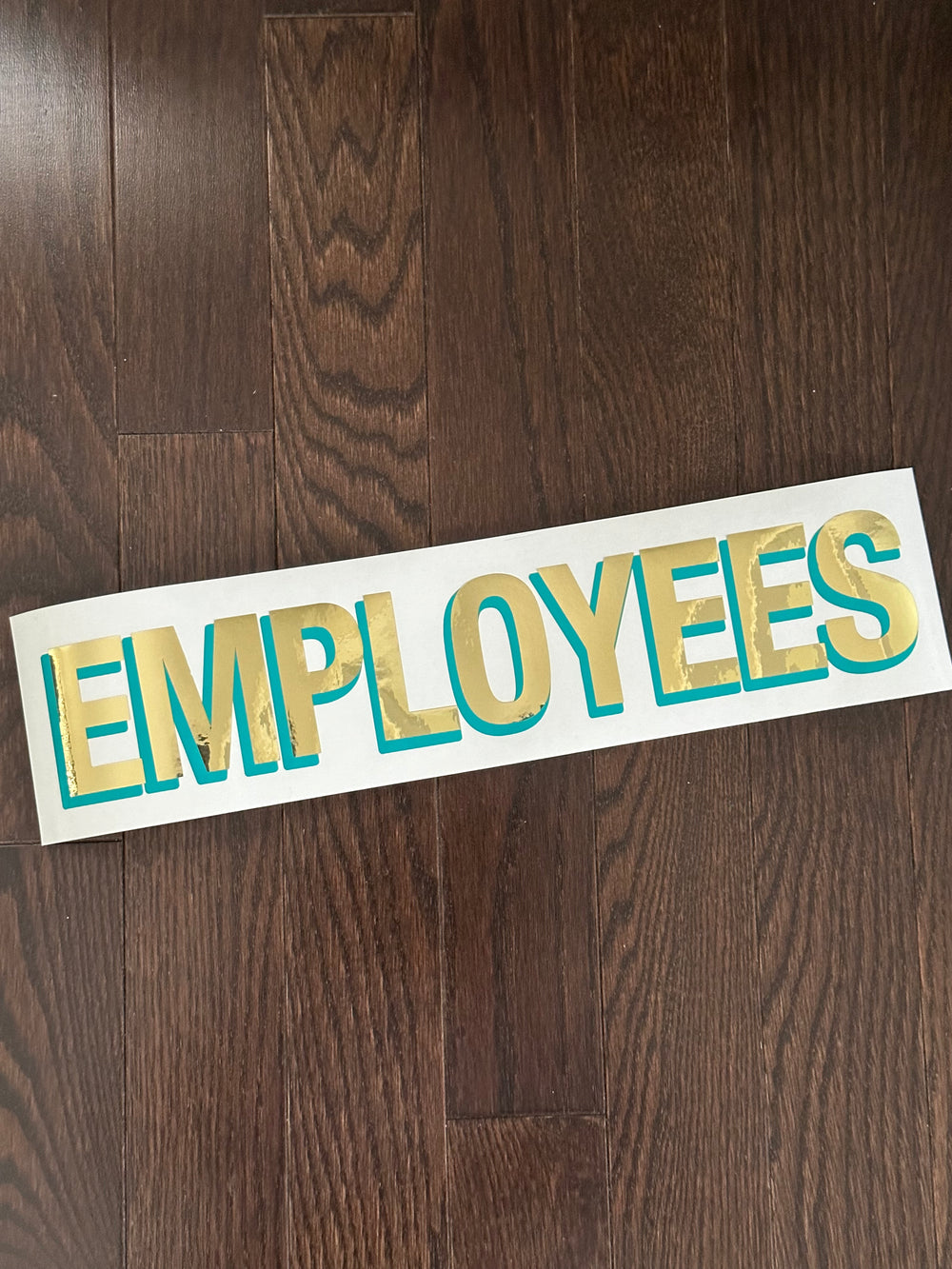 Gold and teal Employees lettering on backing