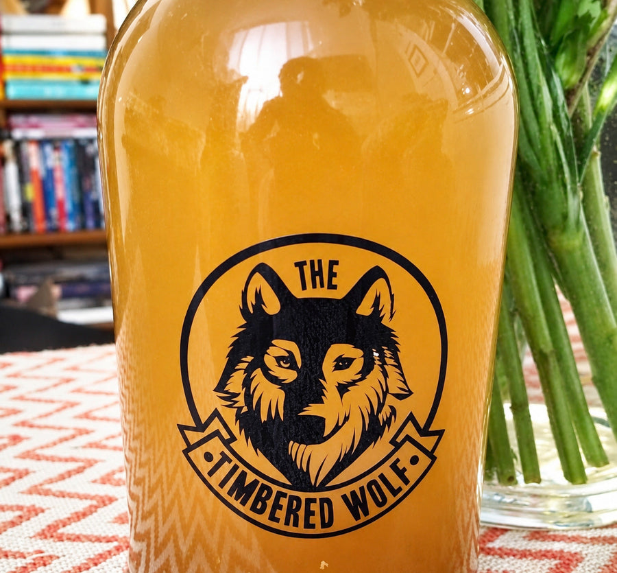 Black The Timbered Wolf logo decal on a drinking glass