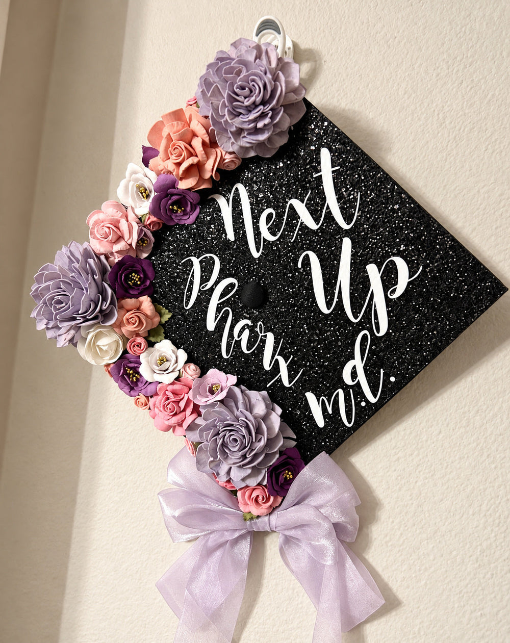 White Next Up Pharm. D. lettering on a decorated graduation cap