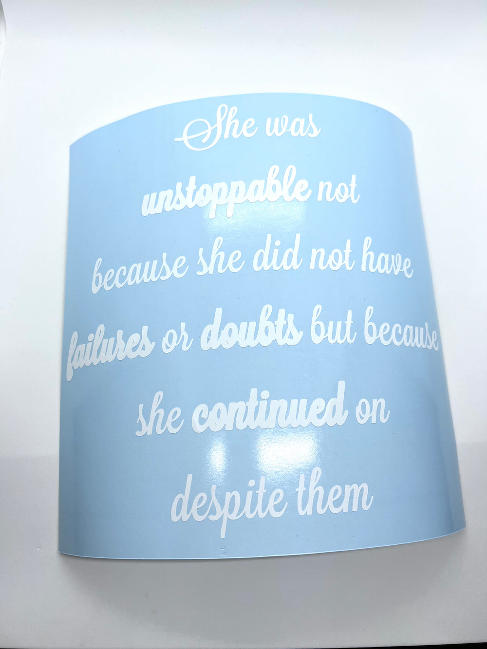 White She was unstoppable graduation quote on blue backing