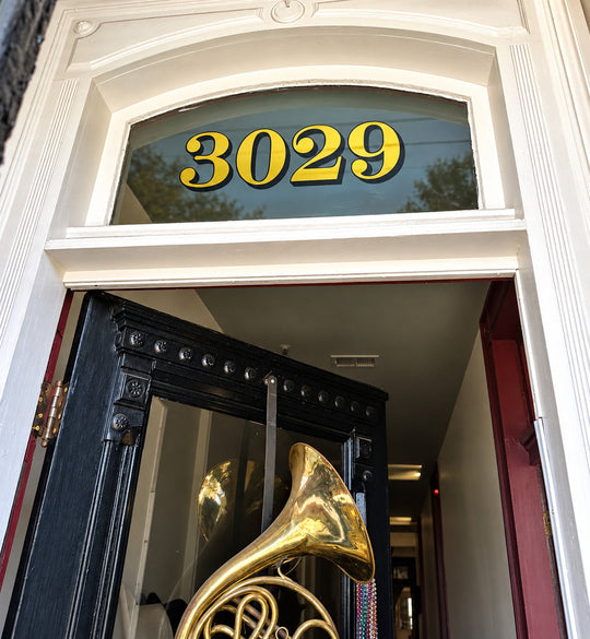 Gold and black 3029 transom numbers installed above an entrance door