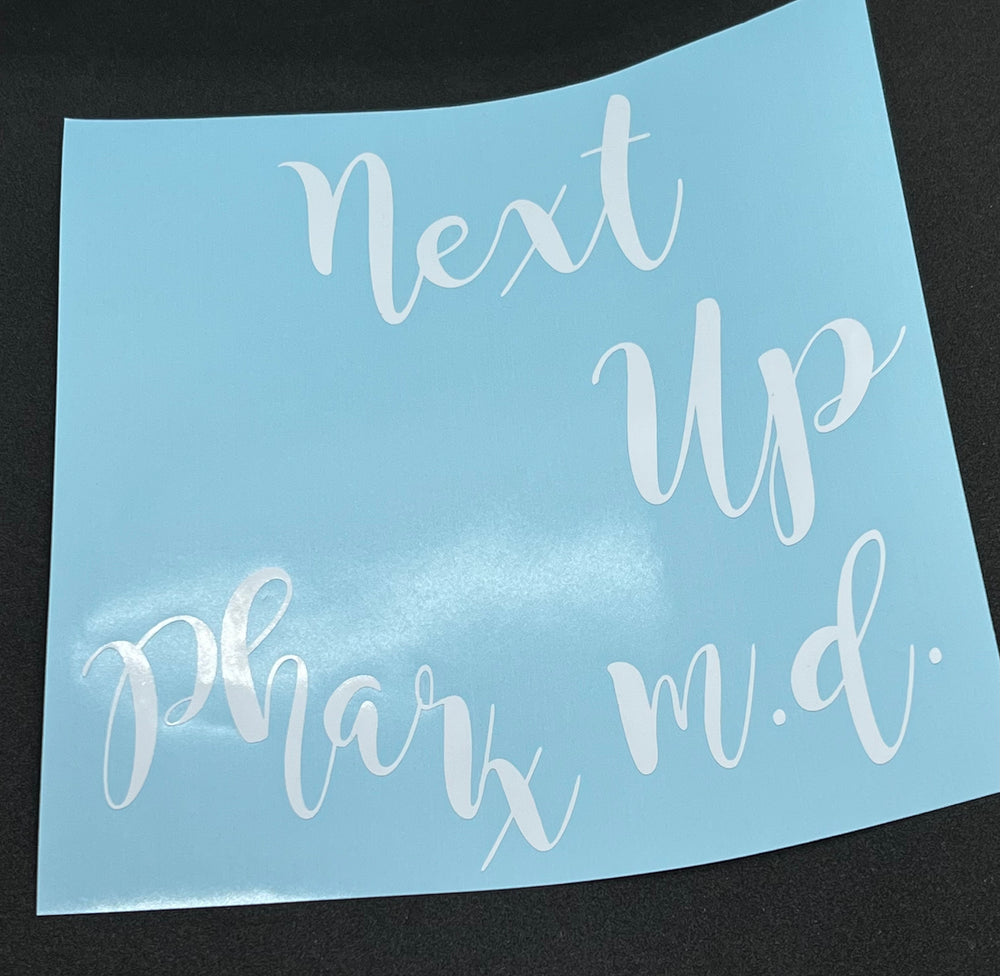 White Next Up Pharm. D. lettering on blue backing