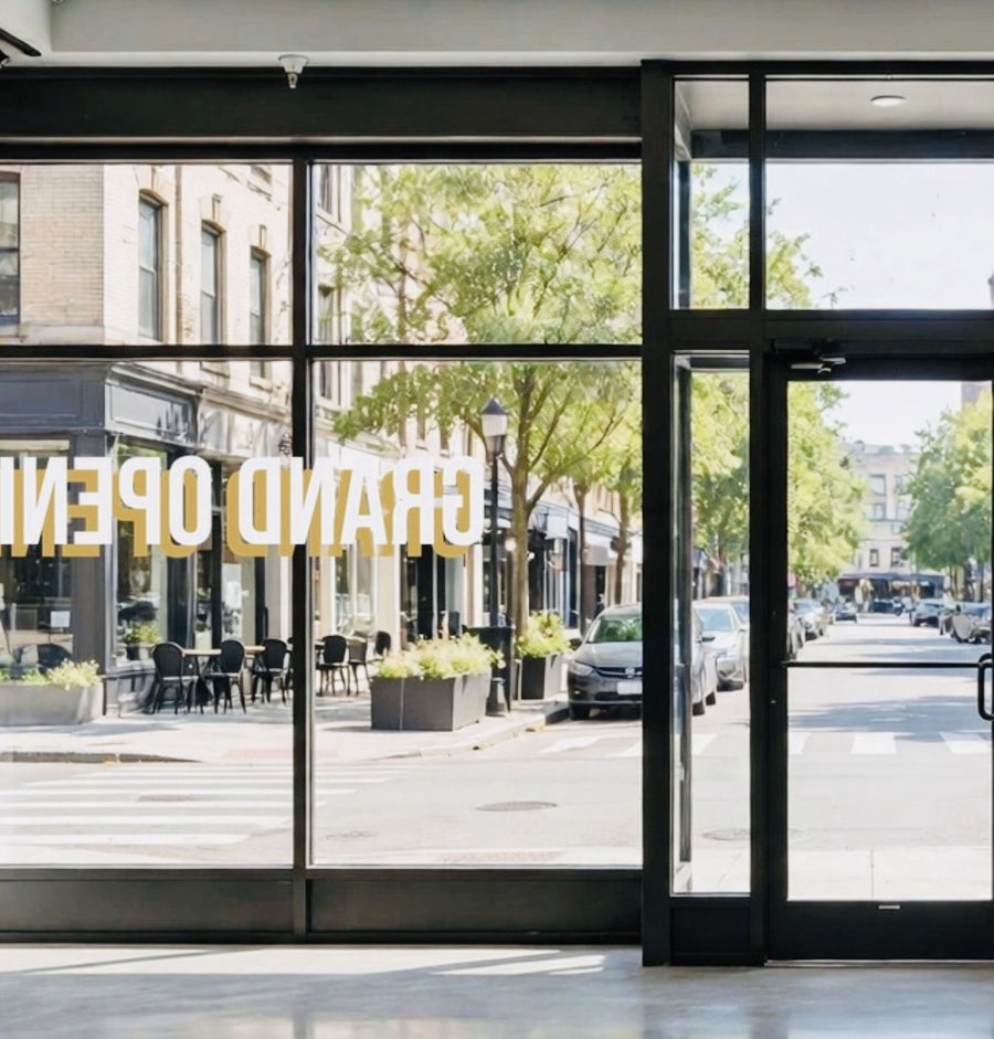 Inside view of reverse-cut decal on storefront glass, lettering reading mirrored from behind