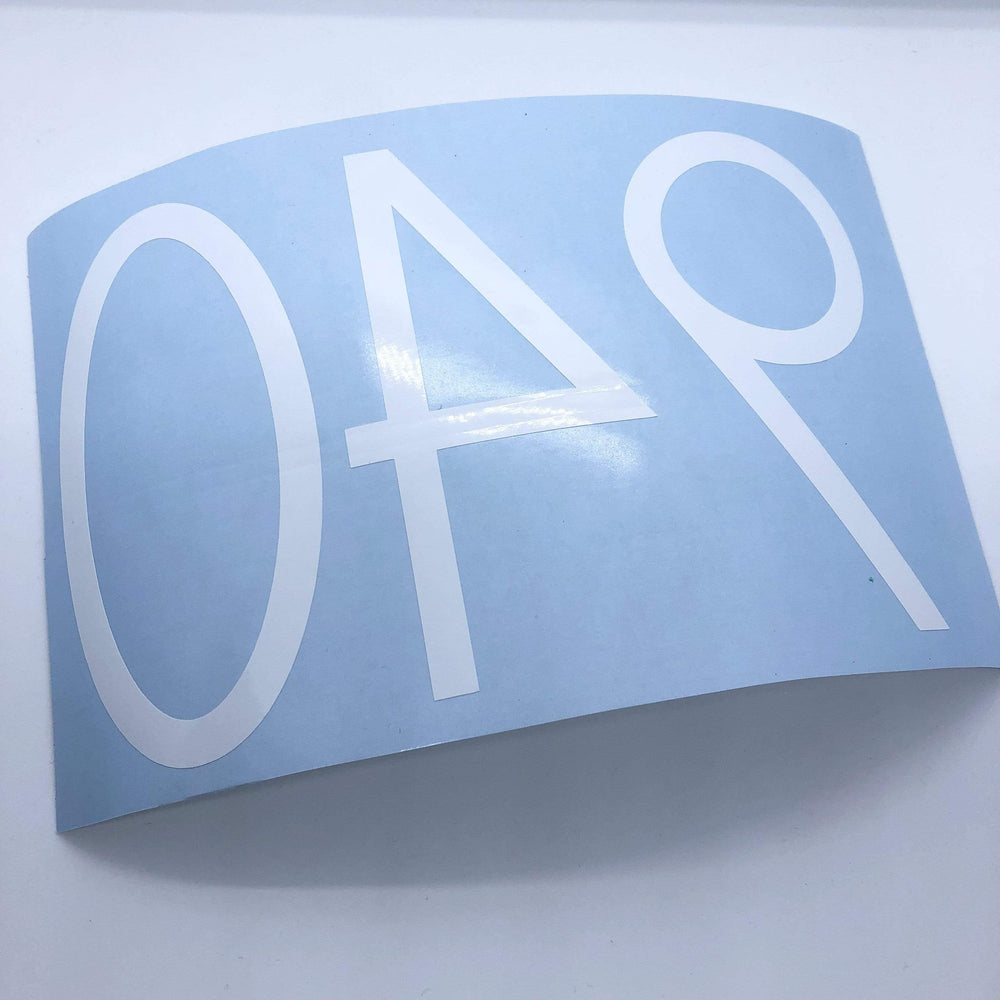 Reverse-oriented white 940 number decal on blue backing