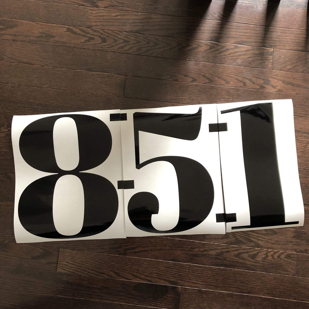 Black 851 number decal laid on a wood surface