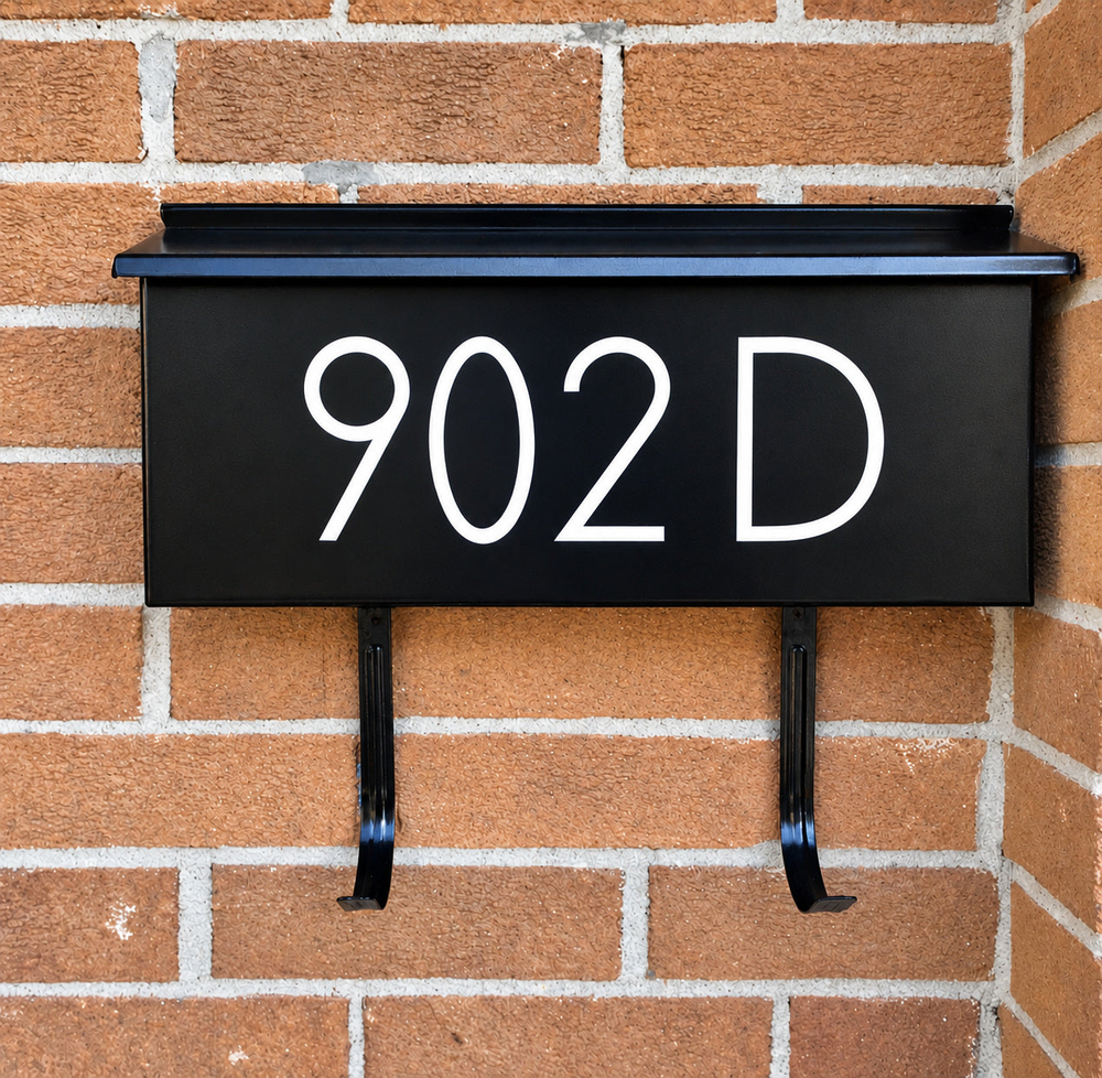 White 902D address lettering on a black wall-mounted mailbox