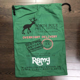 Green Remy Santa sack laid on a wood surface