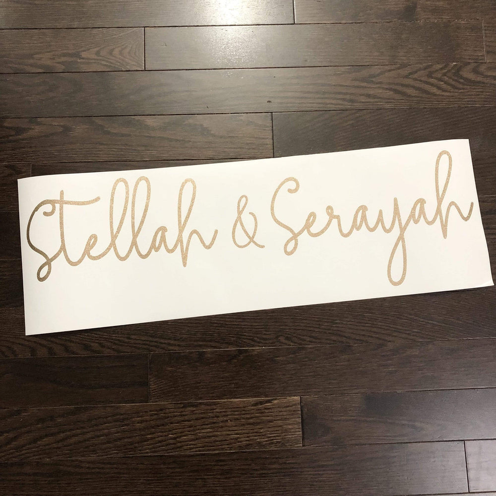 Gold-coloured Stellah & Serayah script lettering on backing