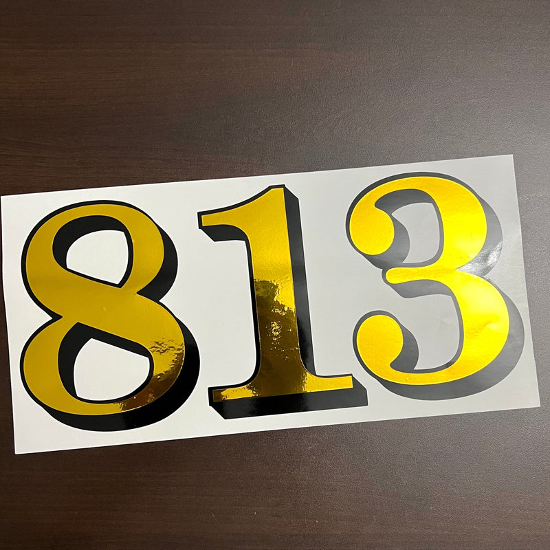 Reflective gold and black 813 number decal on its backing sheet
