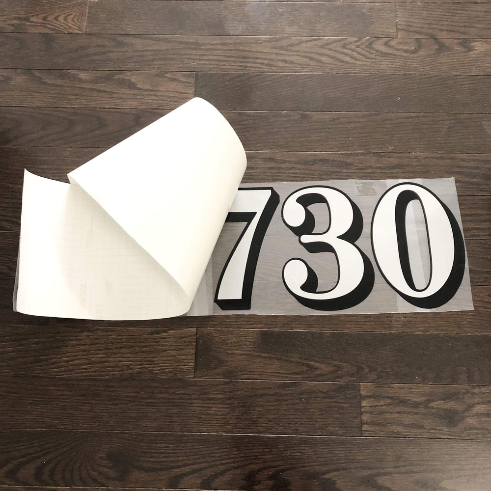 Backing lifted from an outlined number decal