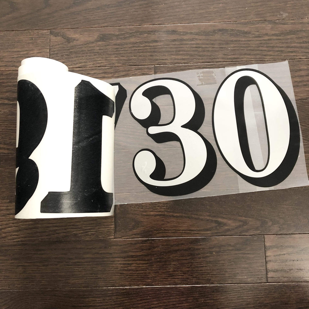 Outlined number decal with backing partly peeled away