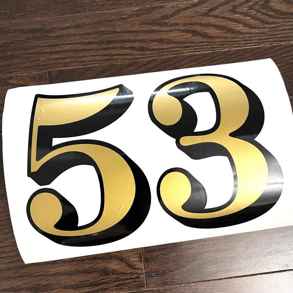 Gold and black 53 digits on a backing sheet