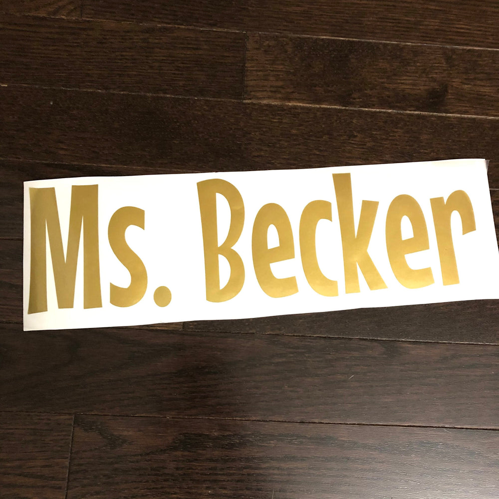Gold-coloured Ms. Becker lettering on backing