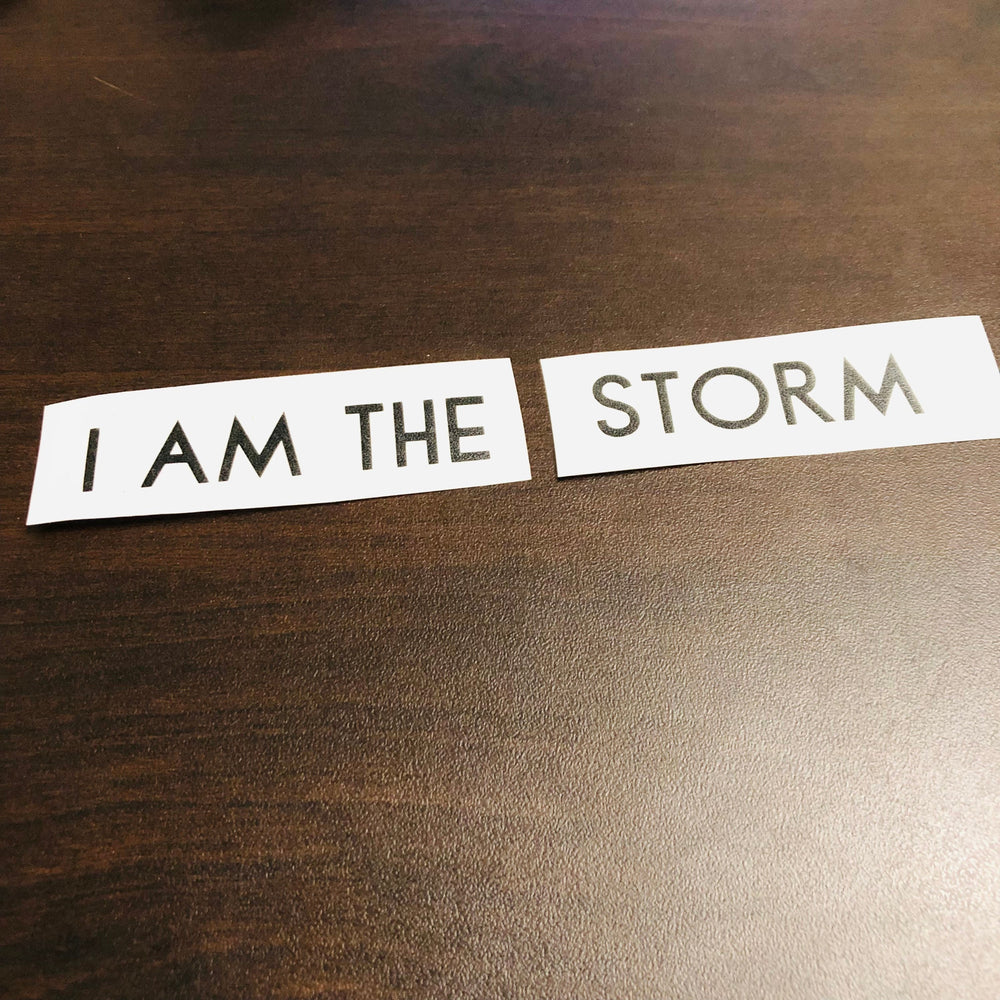 Black I am the Storm lettering strips on wood
