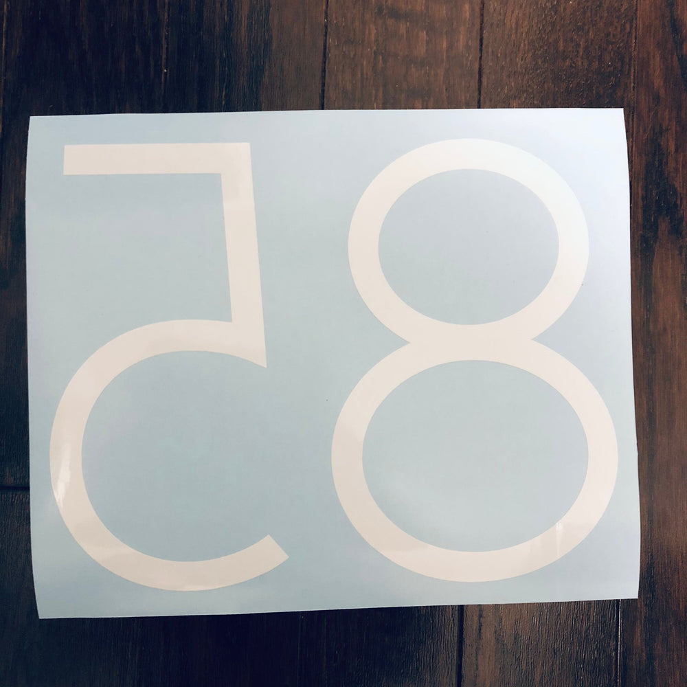 Reverse-oriented white 85 number decal on blue backing