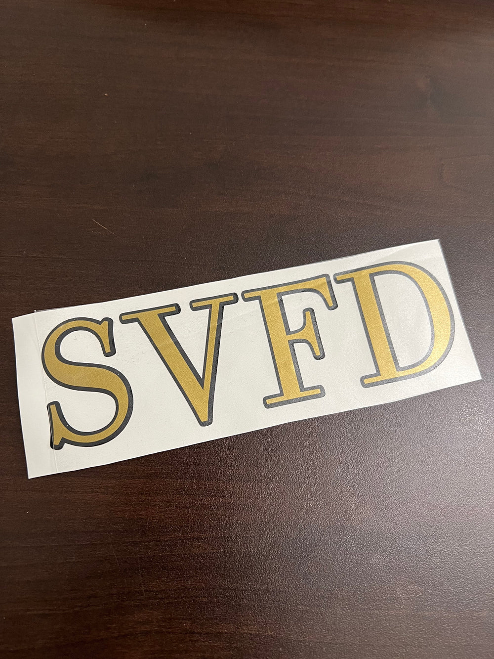 Outlined SVFD lettering on backing