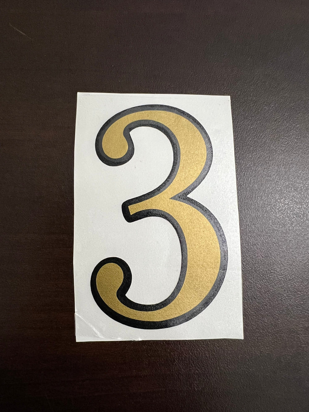 Gold-coloured digit 3 with a dark outline
