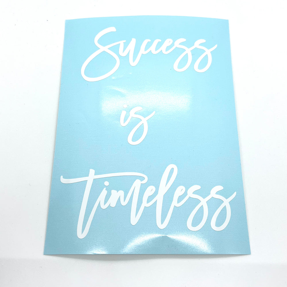 White Success is Timeless lettering on blue backing